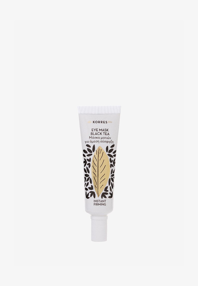 Masque pour les yeux Korres Thé Noir, un tube blanc avec un design en feuilles dorées, des accents floraux noirs et le texte "Serrage Instantané", taille compacte.