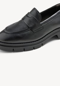 Mocassin en cuir noir au design épuré, avec un détail de sangle à l'avant, un bout arrondi et une semelle texturée pour une meilleure adhérence.