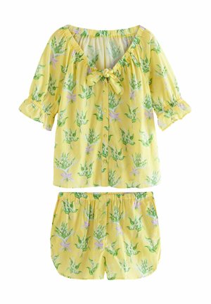 Geel bloemen pyjama set bevat een button-down, kortefris top met een strik aan de voorkant en shorts met elastische tailleband, beide met groen en paars patroon.