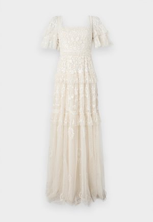 Robe en dentelle de couleur ivoire clair avec des manches courtes à volants et un décolleté carré. Présente un design superposé et en couches avec une broderie florale.