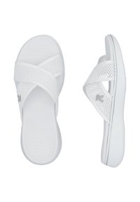 White slide sandals made of perforated material, featuring crossed straps and a textured footbed. Lightweight sole with subtle design accents.
