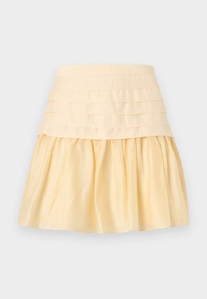 Φούστα υπόλευκη με φαρδιά εφαρμοστή μέση και φουντωτό, πιετάτο κάτω μέρος από λείο ύφασμα.