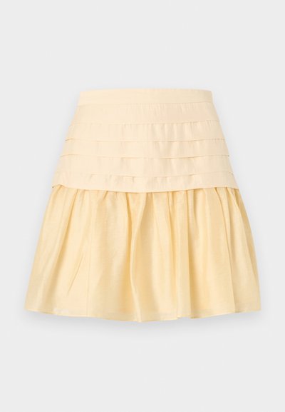 Φούστα υπόλευκη με φαρδιά εφαρμοστή μέση και φουντωτό, πιετάτο κάτω μέρος από λείο ύφασμα.