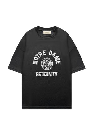 T-shirt en mesh noir à manches courtes avec un texte blanc usé « NOTRE DAME » en arc-dessus d'un emblème circulaire et « RETERNITY » en dessous.