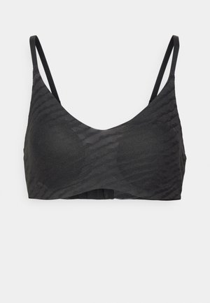 Svart bralette laget av teksturert stoff, med tynne justerbare stropper og en sømløs design med et subtilt bølge mønster.