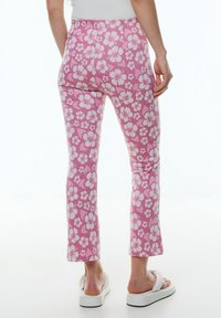 Roze bloemenleggings met een slim fit ontwerp, voorzien van witte hibiscuspatronen, korte lengte en een gladde textuur.