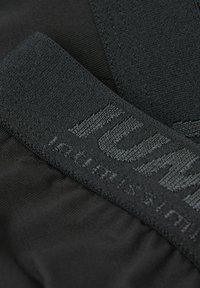 Pantalones cortos deportivos negros con tejido texturizado; cuenta con una cinturilla ancha con letras en relieve y detalles de costura. Material suave y elástico.
