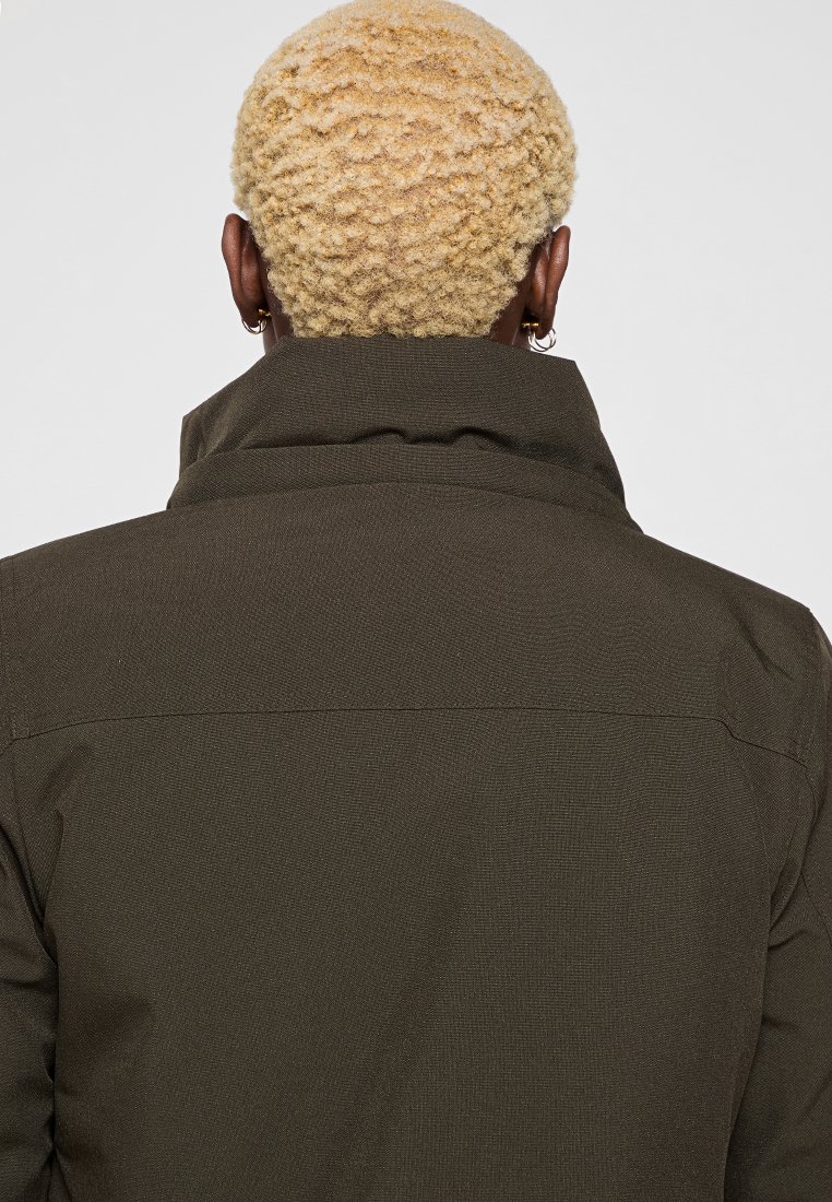 Manteau vert olive avec un col haut et un tissu texturé. Présente des détails de couture et un design droit. Vue de dos uniquement.