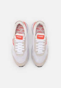 Białe siateczkowe i beżowe zamszowe sneakersy z pomarańczowymi akcentami i białymi sznurowadłami. Posiadają profilowaną wkładkę z wzorem logo. Czarna gumowa podeszwa.