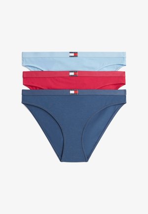 Trois slips de bikini Tommy Hilfiger en bleu clair, rouge et bleu marine, empilés avec les étiquettes de la marque centrées sur les ceintures.