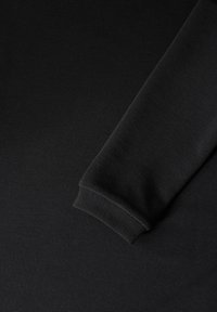 Schwarzes Langarmkleidungsstück mit gerippter Textur und Bündchen. Glattes Material mit dezenten horizontalen Linien, das eine taillierte Passform aufweist.