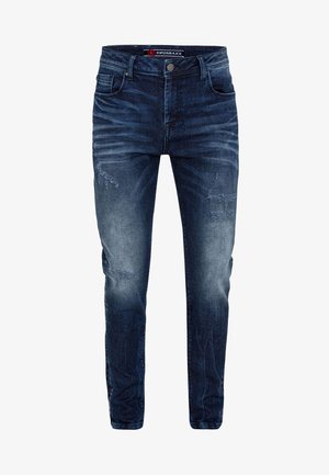 Dunkelblaue Denim-Jeans im Slim-Fit, mit verblassten Akzenten und abgewetztem Patches. Klassisches Fünf-Taschen-Design, Metallknopfverschluss.