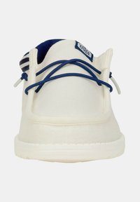 Scarpa slip-on in tela bianca con lacci e dettagli in blu navy. Presenta una suola testurizzata e un dettaglio in tessuto a righe sul tallone.