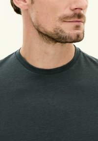 Mörkgrå crew-neck t-shirt i mjukt bomull, med korta ärmar och en slät textur, med en enkel och ren design.