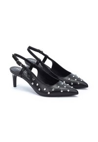 Zapatos de tacón negro de piel con punta fina, adornados con tachuelas de pirámide plateadas en la parte delantera y un tacón de altura media.