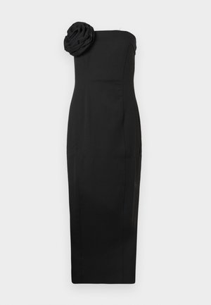 Robe noire sans bretelles avec une silhouette ajustée, présentant un accent floral texturé sur un côté. Conçue pour un look élégant et structuré.