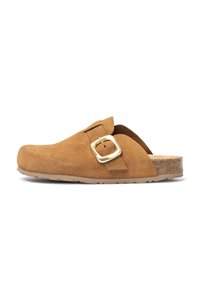 Zoccolo in suede marrone con una larga fascia e dettaglio in metallo. Suola interna in sughero sagomata e suola in gomma testurizzata per una maggiore aderenza.