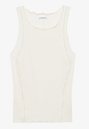 Hvit ermeløs tanktopp laget av ribbet stoff, med en scalloped halslinje og subtil hevet søm langs kantene.