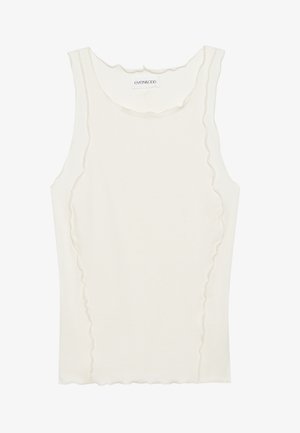 Hvit ermeløs tanktopp laget av ribbet stoff, med en scalloped halslinje og subtil hevet søm langs kantene.