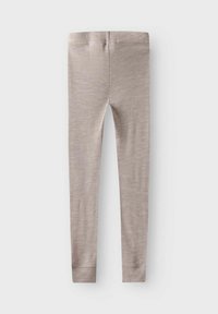 Jasne taupe legginsy o prążkowanej fakturze, elastycznym pasie w talii i dopasowanym kroju; zwężane nogawki kończą się ciasnymi mankietami.