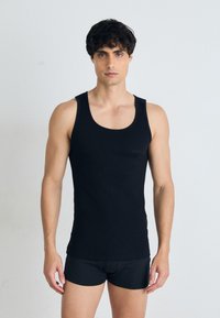 Débardeur noir sans manches avec un col rond, fabriqué dans un tissu lisse ; présente un logo subtil imprimé sur le devant.