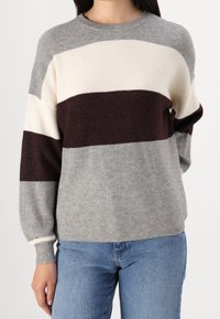 Sweter dziany w szare, kremowe i bordowe paski. Posiada prążkowaną teksturę oraz okrągły dekolt z dopasowanymi mankietami.