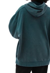 Felpa oversized in teal in morbido tessuto con cappuccio regolabile e orlo rifinito, dotata di etichetta logata laterale e spalle scese.