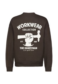 Brauner Pullover mit einem Grafikmotiv eines erhobenen Faust, die einen Hammer hält, sowie den weißen Texten "WORKWEAR COLLECTION" und "THE HANDYMAN".