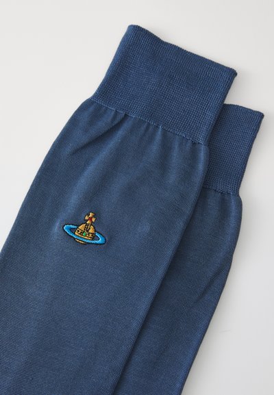 Marineblaue Socken mit geripptem Bund; mit einem gestickten Design einer Glocke in einem blauen Ring. Glatte Textur, mittellange Länge.