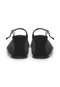 Ein Paar schwarze Ballerinas mit Knöchelriemen und kleinen silbernen Schnallen, von hinten auf einem weißen Hintergrund gezeigt.