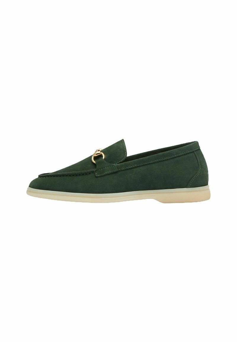 Groene suède loafers met een gouden accent, puntige neus en lage beige zool, voorzien van een gestikt ontwerp langs de rand en een gladde textuur.