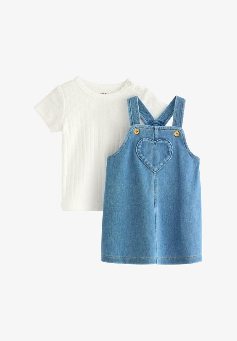 Weißes, geripptes Kurzarmshirt, kombiniert mit einer blauen Denim-Latzhose, die mit einer herzförmigen Tasche und gelben Knöpfen an den Trägern ausgestattet ist.