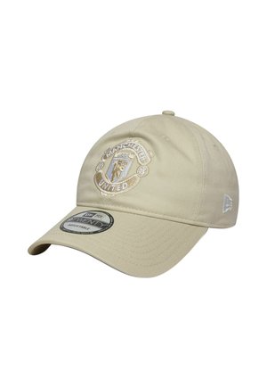 Beige verstellbare Baseballkappe mit auf der Vorderseite gesticktem Manchester United-Logo und einem Markenaufkleber auf dem gebogenen Schirm.