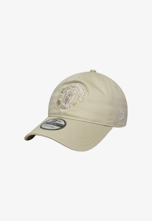 Beige verstellbare Baseballkappe mit auf der Vorderseite gesticktem Manchester United-Logo und einem Markenaufkleber auf dem gebogenen Schirm.