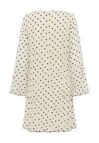 Robe crème à manches longues avec pois noirs et plis subtils, vue de dos.