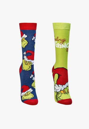 Socken mit einem Cartoon-Grinch-Motiv; die linke Socke hat einen blauen Hintergrund mit roten Akzenten, die rechte Socke ist grün mit weißer Schrift.