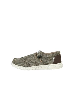 Chaussure décontractée sans lacets en tissu tricoté vert olive, semelle beige tachetée, patch marron au talon et fermeture à lacets à bascule sur fond blanc.