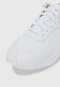 Adidași albi din material sintetic neted, cu accente texturate și limbă căptușită, cu închidere clasică cu șireturi. Talpă din cauciuc.