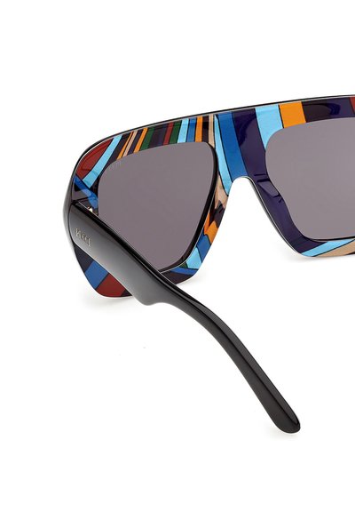 Gafas de sol con lentes grandes y oscuras y una montura de rayas multicolores, con una patilla negra con la marca "Pucci".