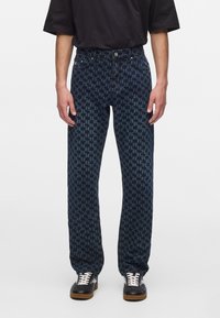 Tumed sinised teksad, millel on hunduhammust (houndstooth) muster, sirge lõige, denim-materjal, viis taskut ning nööp- ja tõmblukk.