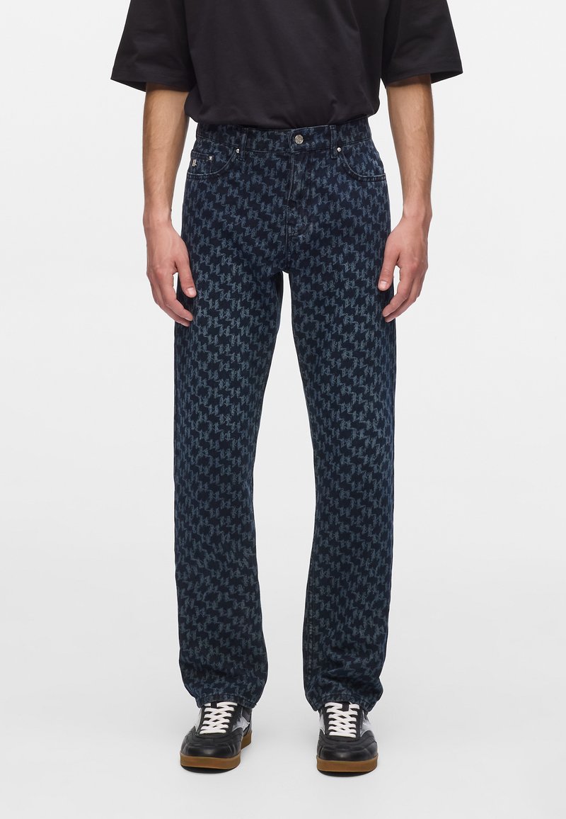 Tumed sinised teksad, millel on hunduhammust (houndstooth) muster, sirge lõige, denim-materjal, viis taskut ning nööp- ja tõmblukk.