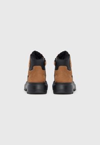 Ghete din piele întoarsă maro și material sintetic negru, cu un finisaj texturat, prevăzute cu un inel pentru tragere și o talpă de cauciuc pentru aderență sporită.