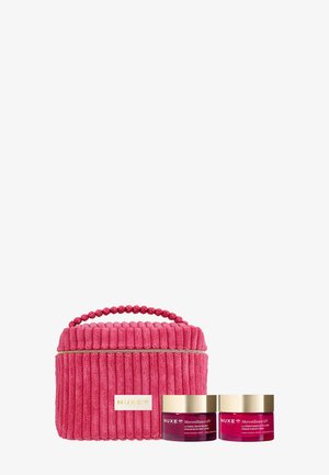 Trousse de toilette rose texturée avec poignée à côté de deux pots de soins NUXE Merveillance LIFT avec couvercles dorés sur fond blanc.