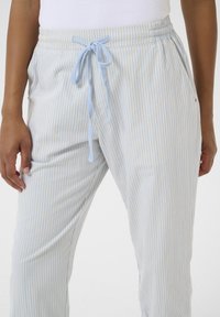 Keveä, raidallinen yöhaalari sinisessä ja keltaisessa. Varustettu joustavalla vyötäröhihnalla, jossa on nyöri, sekä sivutaskuilla. Pehmeä kangastuntuma.