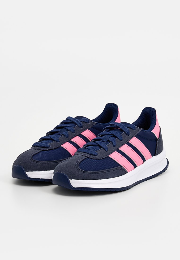 Chaussures de sport bleu marine avec des accents roses, dotées d'un haut en textile, d'une semelle blanche et de trois rayures roses sur le côté.