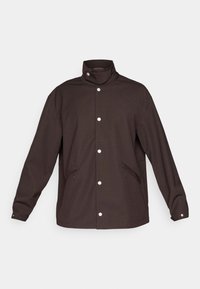 Brown jacket with a high collar, snap buttons, and two zippered side pockets. The fabric appears textured with a slightly relaxed fit.