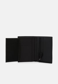 Schwarze Geldbörse mit einem Reißverschlussfach, mehreren Kartenfächern und einer glatten Oberfläche. Das Innere verfügt über eine Netz Tasche und nahtlose Kanten.