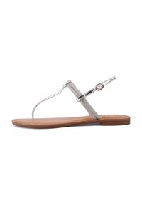 Sandalo thong metallico argento con cinturino testurizzato e accentatura a fibbia circolare, dotato di suola piatta color terra e design minimale.