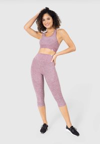 Top corto atletico viola e leggings a vita alta realizzati in tessuto a maglia testurizzato, abbinati a scarpe da ginnastica nere.
