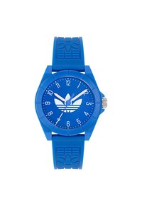 Montre en silicone bleue avec un boîtier rond, des marqueurs d'heure blancs et un logo au centre. Bracelet bleu texturé avec un motif.